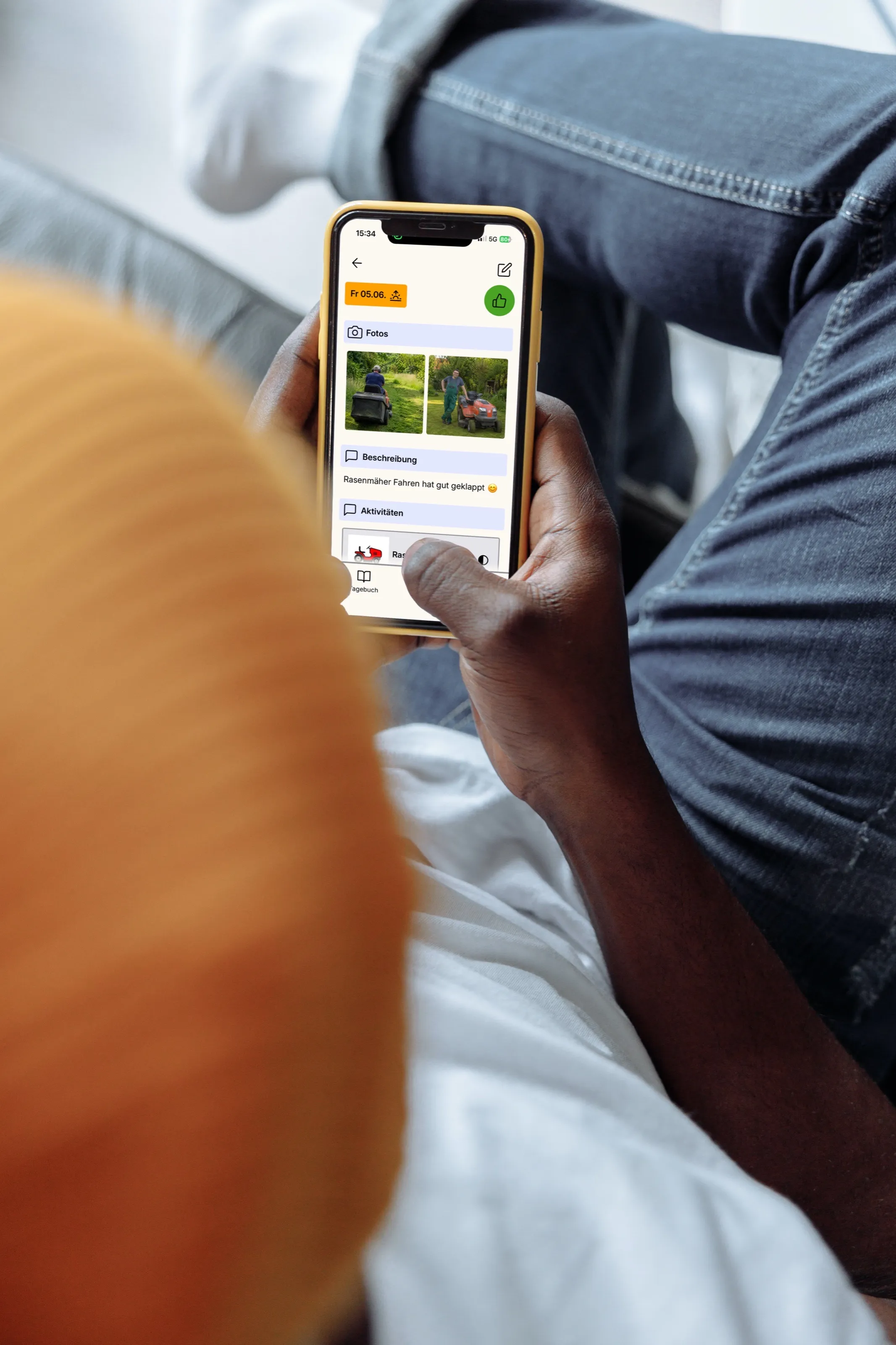 Eine Hand hält ein Smartphone mit der Tagebuch-App; mehrere Einträge sind sichtbar.
